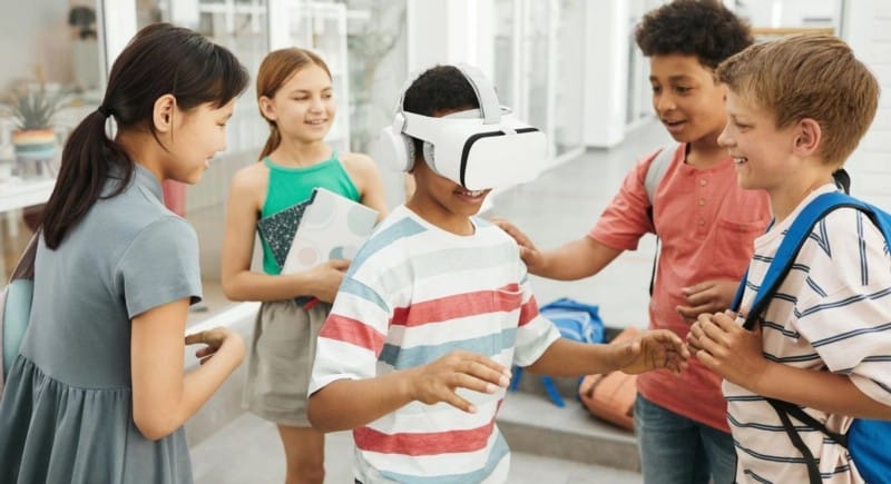 طفل يرتدي نظارة VR مُحاط بمجموعة من الأولاد